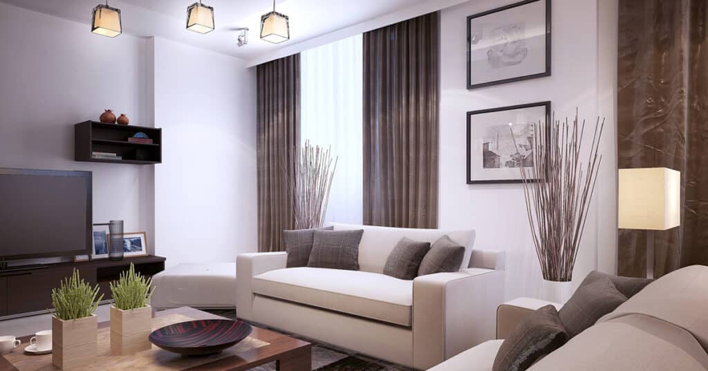 Image of a beautiful small living room with earth tone accents and beautiful brown couches and chairs.